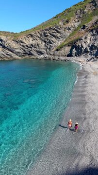 La Frana Beach in Sardinia, Italy, offers breathtaking turquoise waters and a serene atmosphere. Sunlight sparkles on the gentle waves as visitors enjoy the tranquil shoreline and stunning landscape.