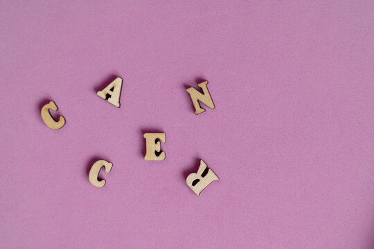 Jumbled letters of the word "cancer" on a pink background.