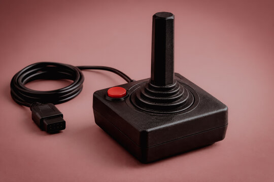 Vintage black joystick controller on pink background