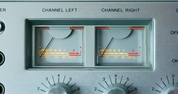 Close up of illuminated VU meters bouncing on vintage audio amplifier or cassette deck
