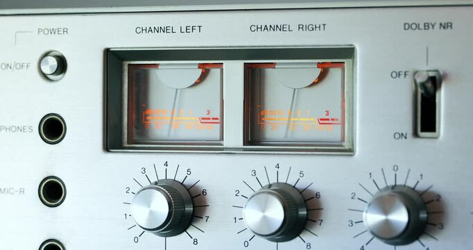Close up of illuminated VU meters bouncing on vintage audio amplifier or cassette deck