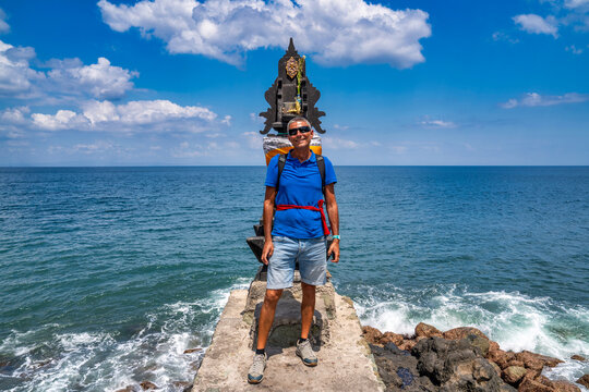 Caucasian male tourist visiting Pura Batu Bolong temple in Lombok Indonesia