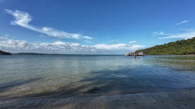 Tropical waterfront with pier and glowing evening clouds