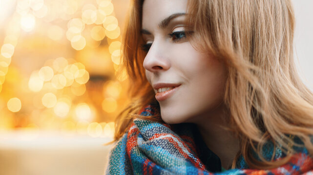 Close-up portrait of a beautiful young woman on the background of yellow lights