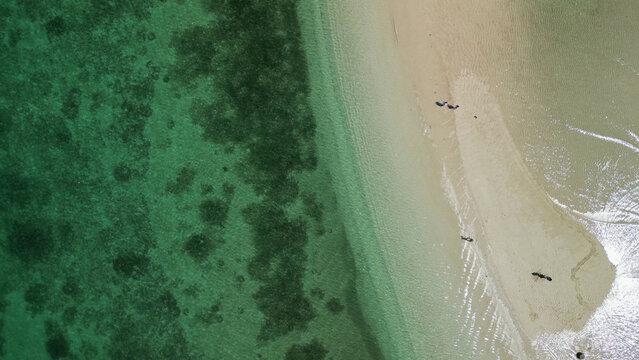 Stunning overhead view Gili Kere Lombok sand tongue with white sandbar coral reef lush greenery and sunny seascape horizon