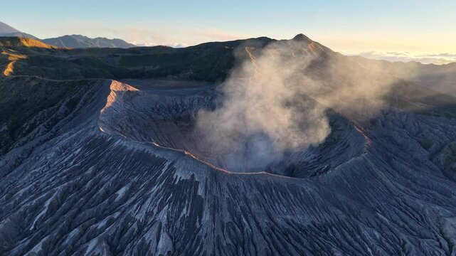 Vast Bromo crater steams gently at dawn. Rugged slopes frame a misty, ancient volcano