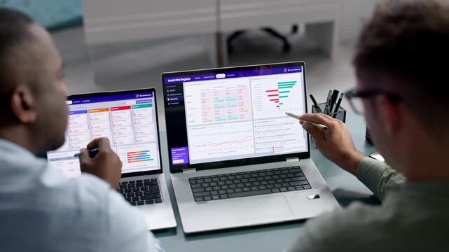 Data Analyst And Manager Review AI Model Risk On Laptop