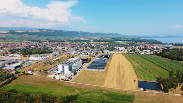 Aerial view shows data center beside wheat field with distant lake view
