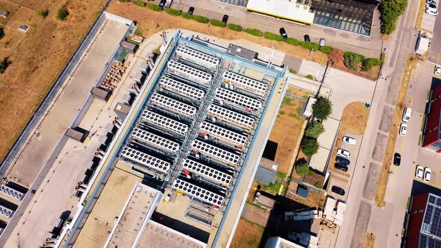 Drone pans rooftop then tilts up revealing data center and solar panels