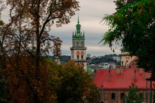 moody cloudy weather in dark European city with shadow from the trees and tower town hall building historical city