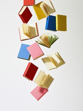 Colorful books floating in white space