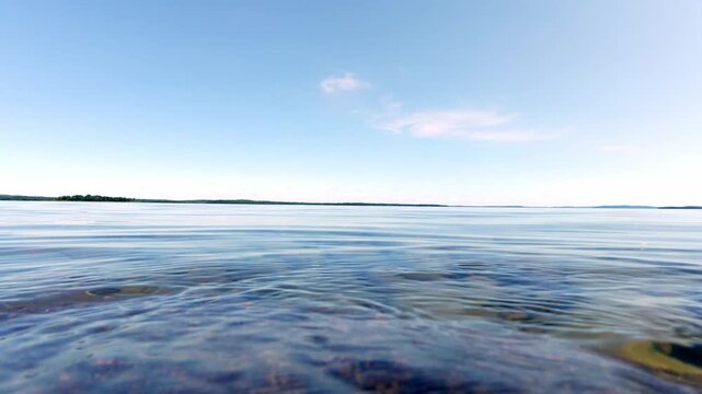 Low-angle waterline footage of gentle ripples across Lake Huron near Manitoulin Island, Ontario, Canada. Minimal natural texture suitable for backgrounds, transitions, relaxation, travel