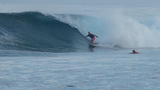 Person surfs perfect ocean wave on the Sultans surfing spot in the Maldives