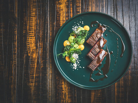 Grilled steak with vegetables on a green plate