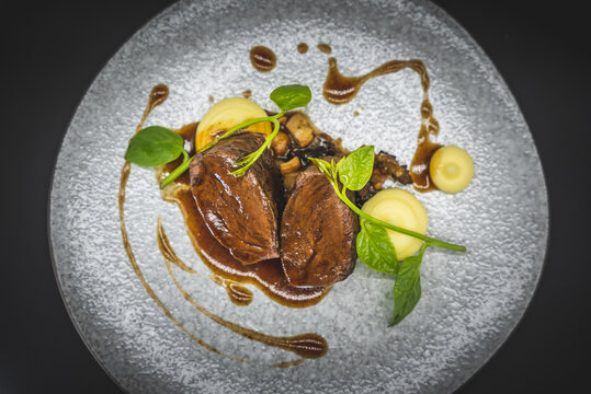 Gourmet plated meat dish with vegetables and sauce