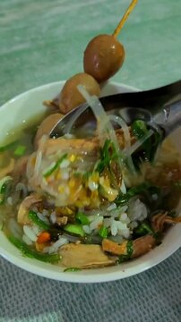 POV hand stirring Indonesian Chicken Soto with Rice
POV hand stirring Indonesian chicken soto with rice, showcasing a traditional savory soup dish and an authentic local food experience.