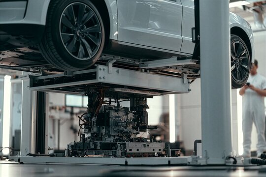 Automated assembly line building a car chassis with robotic machinery shown in vivid detail