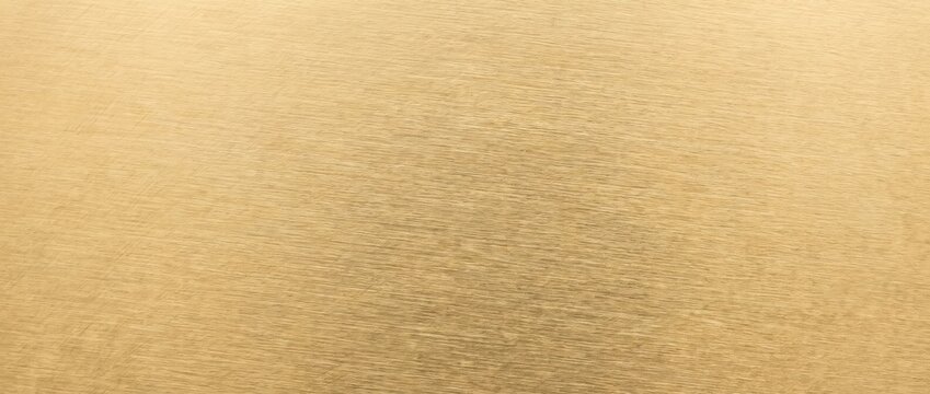 Close up of brushed gold metal surface. Shiny metallic texture with fine lines. Warm festive background with copy space for text