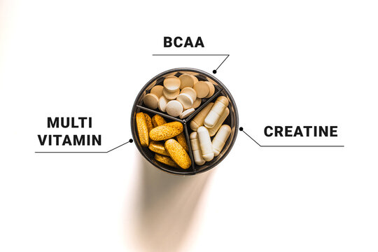 Top view of sport supplement container divided into BCAA multivitamin and creatine sections, fitness nutrition concept