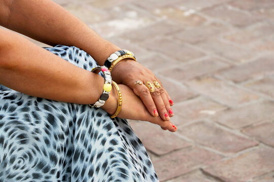 Indian woman wearing traditional gold bangles and rings.