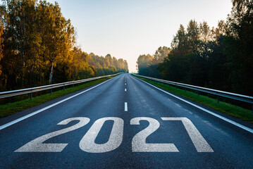 Obraz premium Asphalt highway between forests with the new year 2027 painted on pavement for future planning concepts.