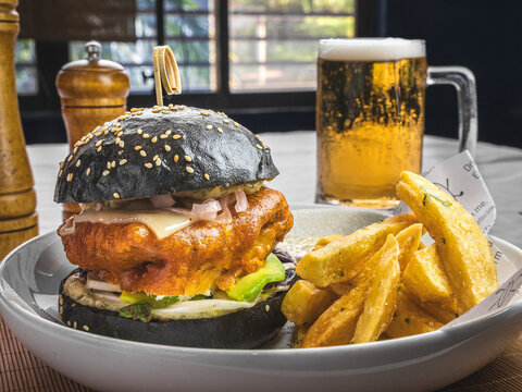Black bun burger with french fries and beer