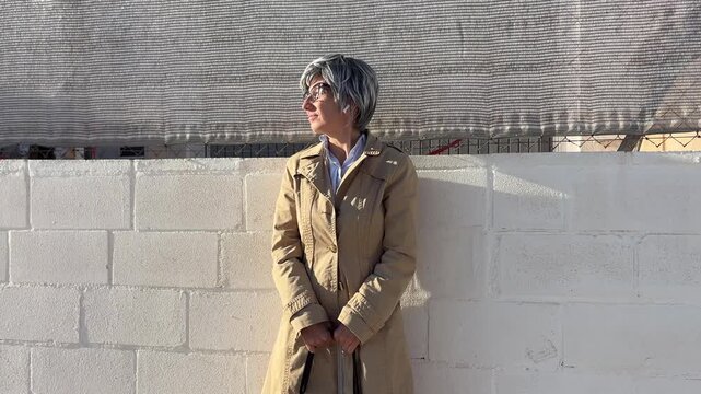 Mujer +50 esperando el autob&uacute;s en un entorno urbano