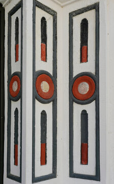 Detail of a historic entrance in Goerlitz with geometric ornaments composed of circles, rectangles and vertical shapes in red, black and white.
