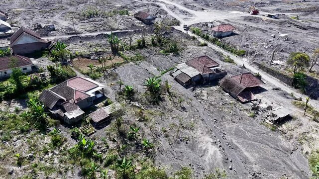 Drone aerial over abandoned houses buried by ash and lava after Mount Semeru eruption supiturang