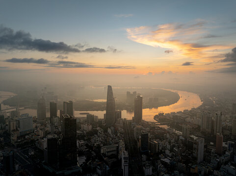 Saigon skyline and winding river beneath warm clouds, Ho Chi Minh City, Vietnam