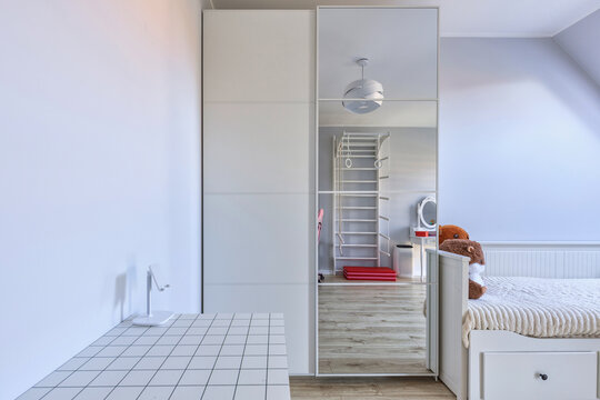 Childs bedroom in white and gray colors with a desk.