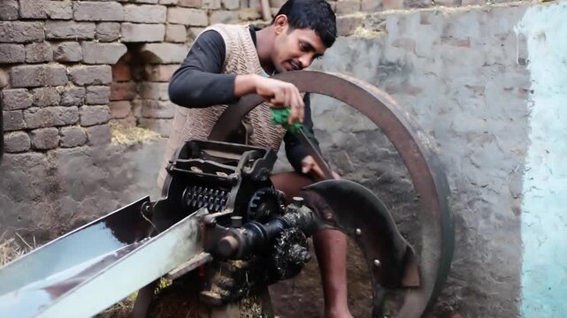 Men sharpening the blades of chaff cutter or kutti machine using whetstone   