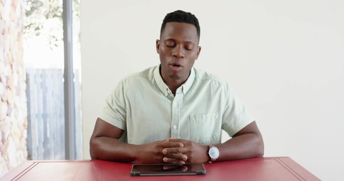 Close up of people talking to the camera, man sitting at table with tablet, speaking and gesturing w