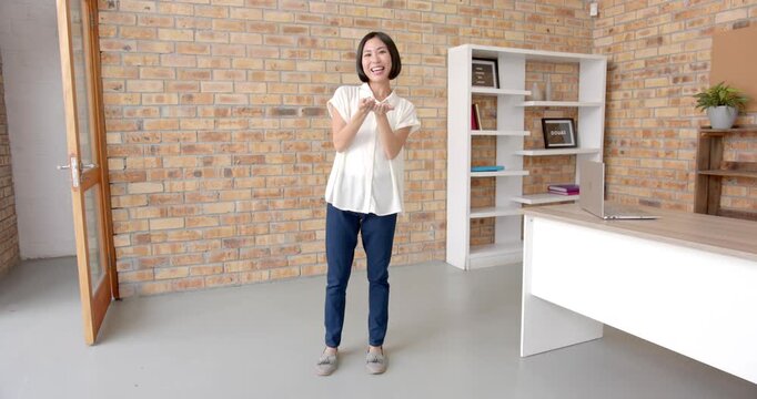 Close up of people talking to the camera, smiling woman standing in office, gesturing with hands