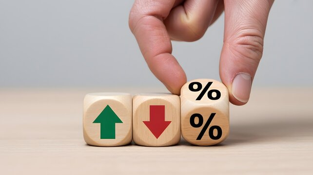A close-up photograph of three wooden dice showcasing symbols for increasing and decreasing interest rates or financial growth trends