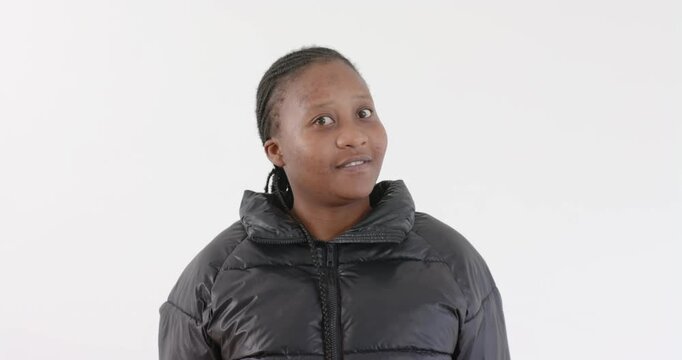 High-speed photography for dynamic scenes, smiling woman in black jacket posing against white backgr