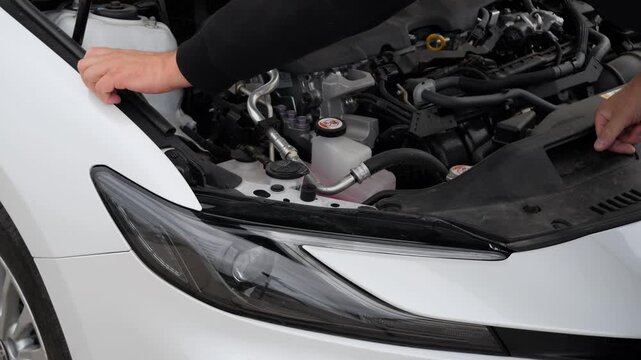 Driver examines the engine compartment to identify a possible vehicle malfunction