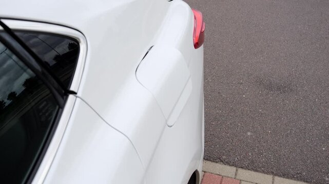 Close up view of a car fuel filler door popping open before refueling