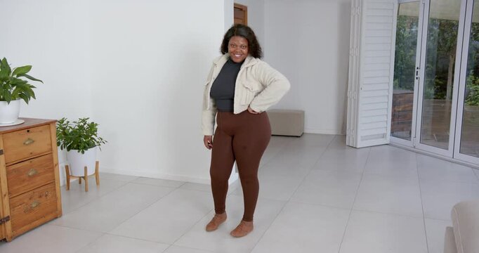 High speed photography for dynamic scenes, woman in brown leggings standing indoors, crossing arms a