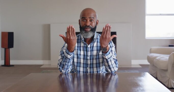 Close up of people talking to the camera, Smiling man in plaid shirt gesturing with hands while sitt