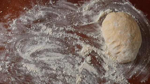 Raw Dough Ball Resting on Floured Wooden Surface Top View