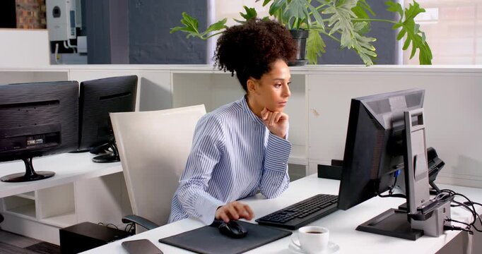 African American woman working at desk using computer in modern office