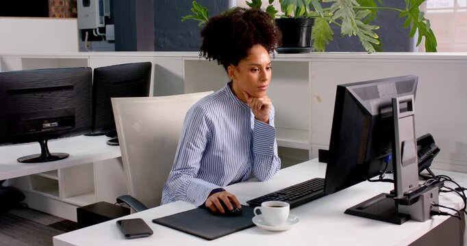 Stressed businesswoman at office desk rubbing temples, seeking relief from headache