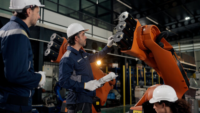Professional robotic technician team working for robot assembly component from customer specifications at robot workshop. precision adjustment.