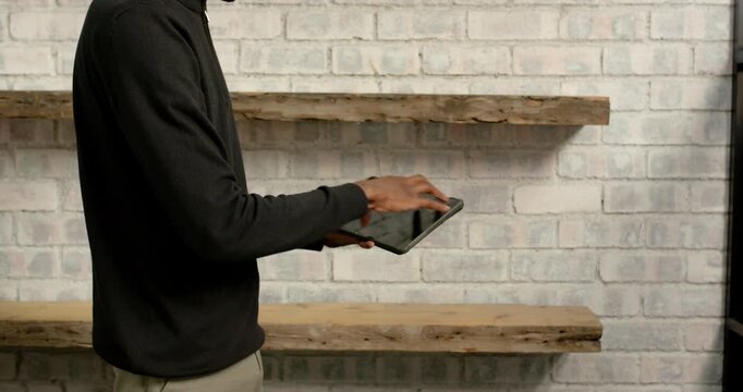 Close up of people talking to the camera, holding tablet, man standing in front of empty wooden shel