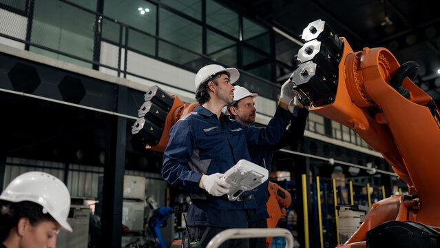 Robotics system integration, Professional robotic technician team working for robot assembly component from customer specifications in robot warehouse. precision adjustment.