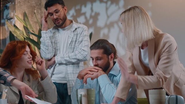 Diversity casual informal group five people discuss problem paperwork difficulty job in startup office women men arguing work bad result team with documents negative talking with building blueprint