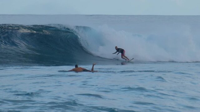 Person surfs perfect ocean wave on the Sultans surfing spot in the Maldives