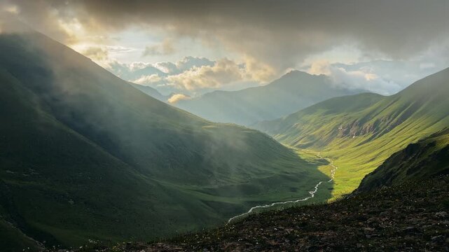 Majestic scenic view of a mountain valley with rolling clouds at sunset. Scenic mountain cascades represent the sustainability and power of nature.
