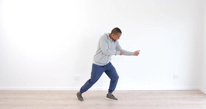 African American man practicing dynamic dance moves in minimalist studio space